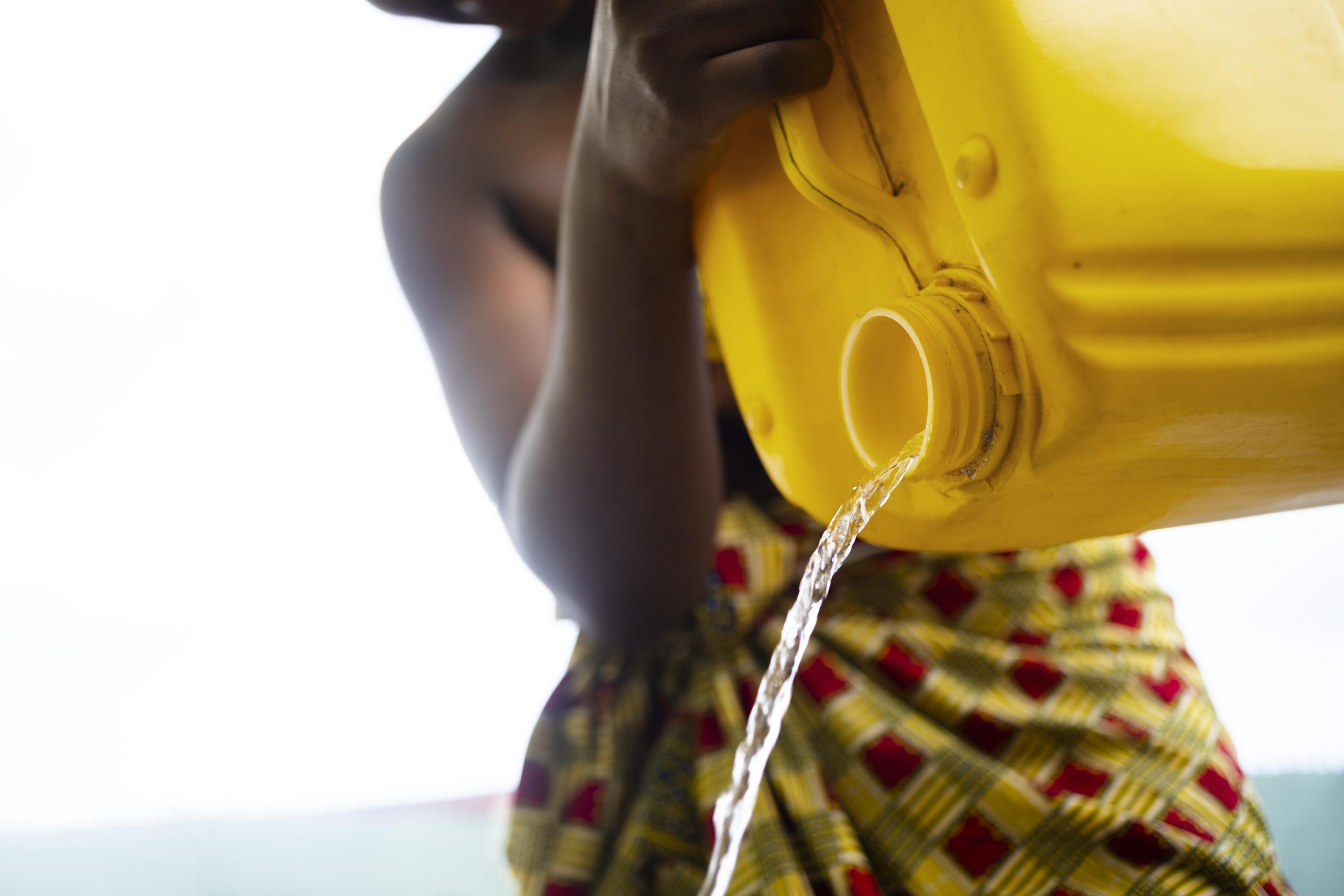 Woman pouring water from a yellow container